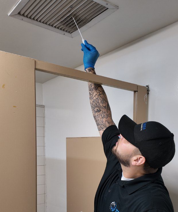 TERRA technician collecting a surface sample at a ceiling supply vent